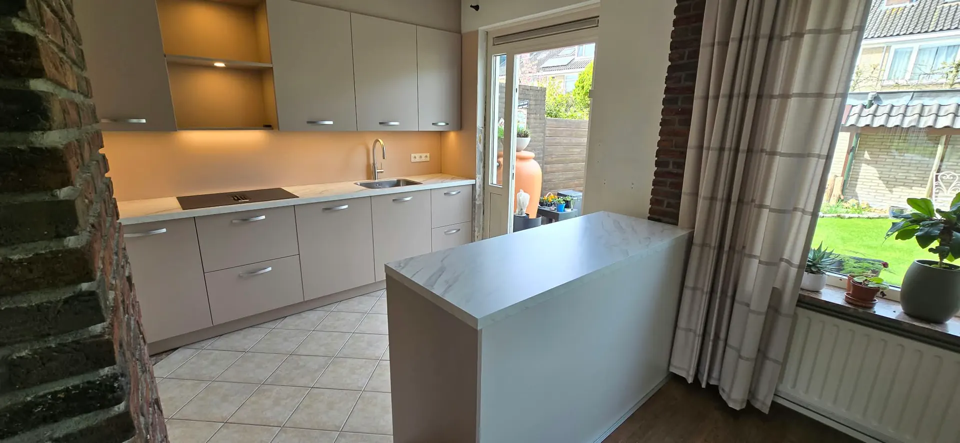 Dezelfde keuken vanuit een andere hoek, met een vrijstaand werkblad op de voorgrond